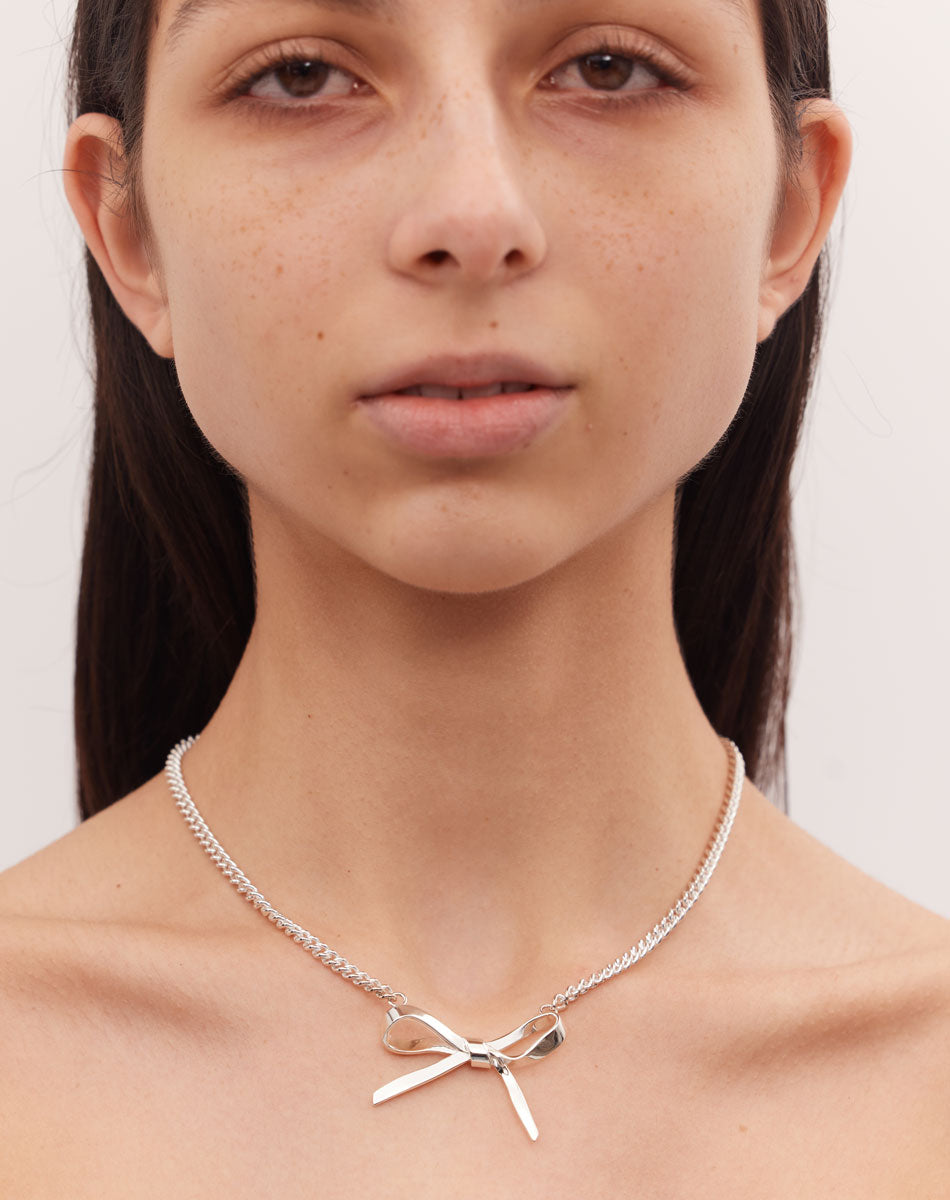 Silver bow necklace on model