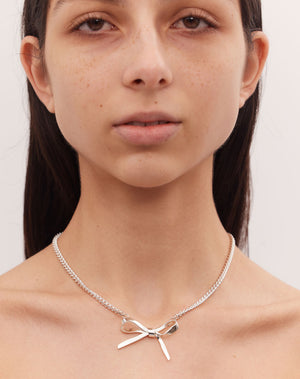 Silver bow necklace on model