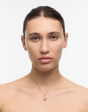 Woman wearing a gold bunny rabbit charm necklace
