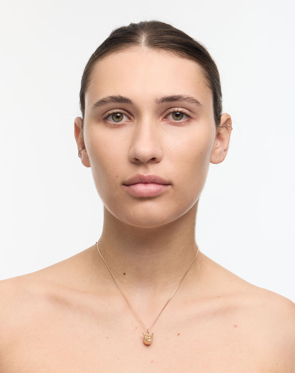 Woman wearing a gold cat charm necklace 