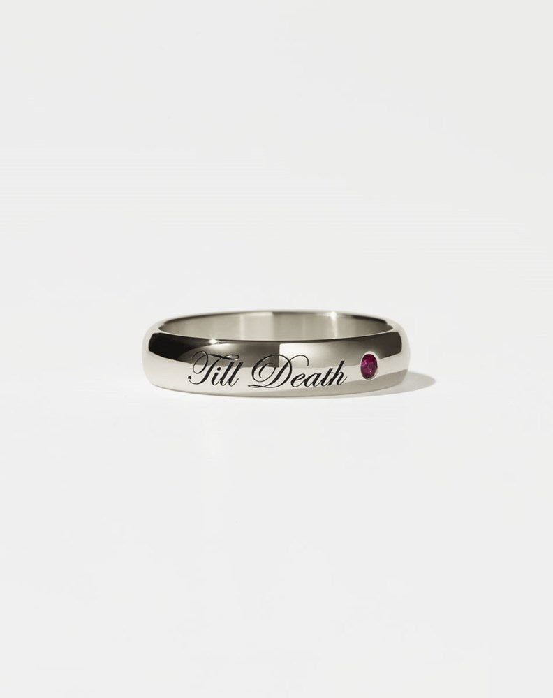 A 9ct white gold band ring with the phrase 'Till Death' engraved on it and a single ruby set in a white gold band.