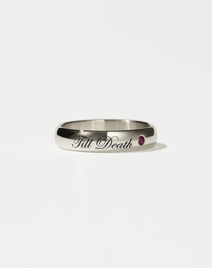 A 9ct white gold band ring with the phrase 'Till Death' engraved on it and a single ruby set in a white gold band.