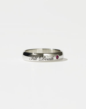 A sterling silver band ring with the phrase 'Till Death' engraved on it, featuring a small ruby on one side.