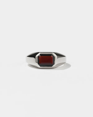 A sterling silver ring with a red Garnet gemstone on a white background. Made by Meadowlark Jewellery in New Zealand.