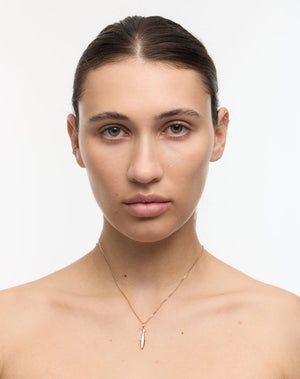 Woman wearing a gold sardine charm necklace