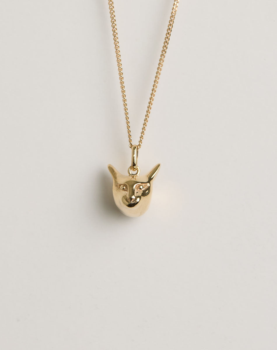Gold charm necklace with a cat-shaped pendant 
