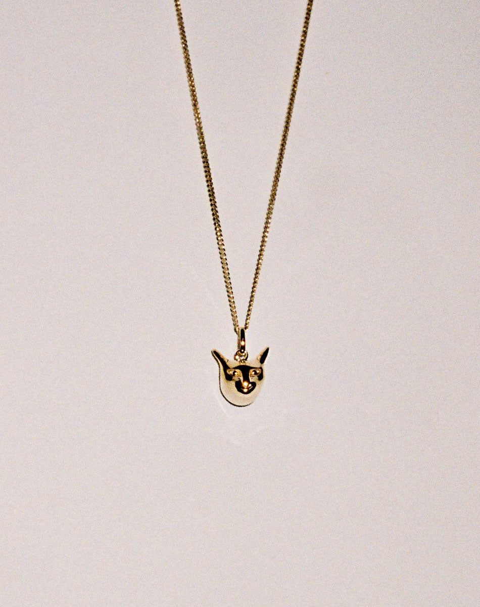 Gold charm necklace with a cat head pendant 