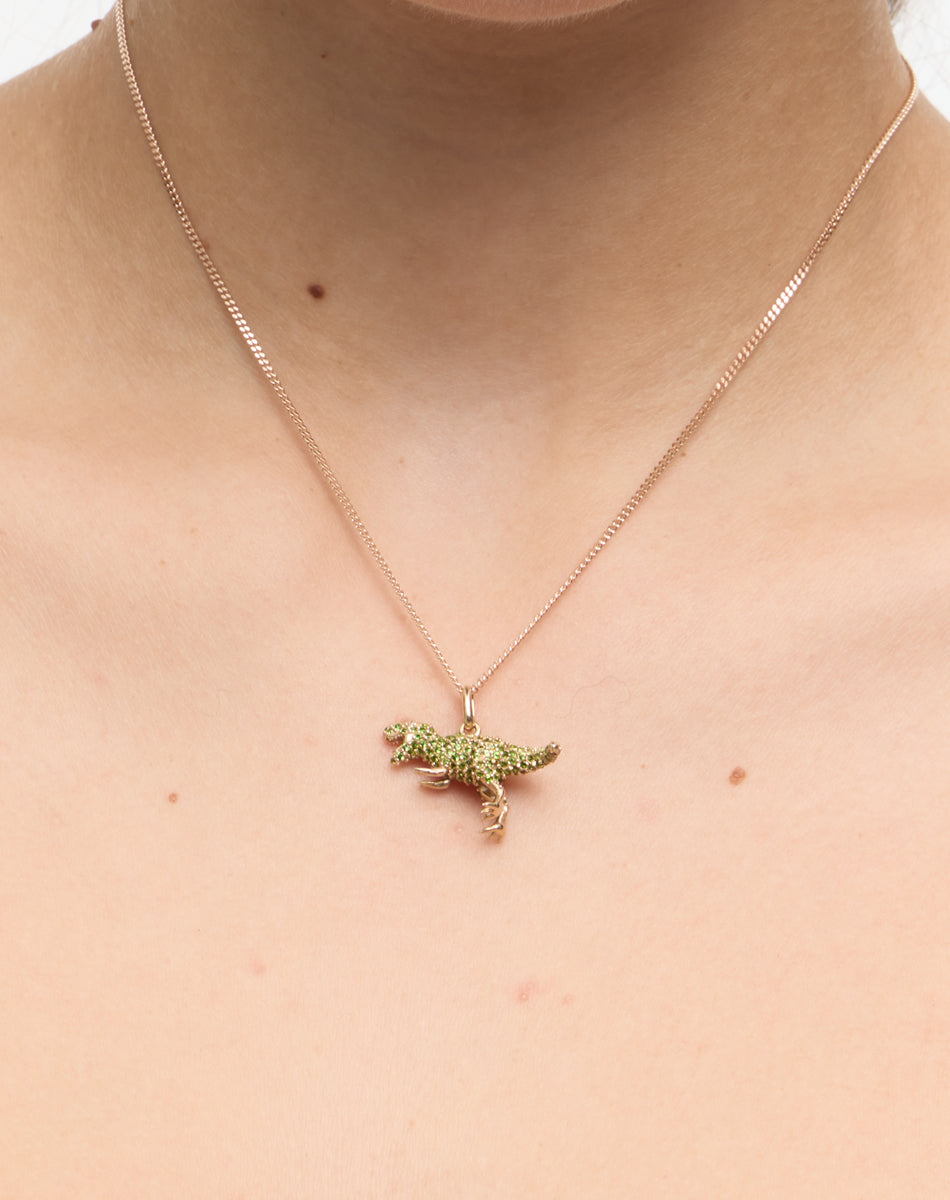 Dinosaur pendant set with green stones worn on model