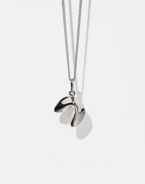 Silver necklace with fortune cookie shaped pendant on a white background