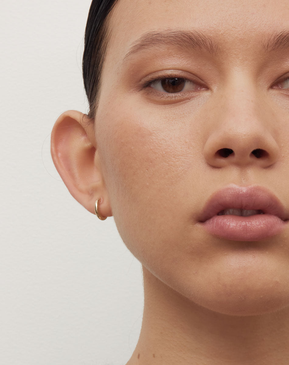Halo Huggies Earrings in 23k Gold Plated or 9ct Yellow Gold with lever or clicker back earring closure. Inner diameter approximately 7mm. Worn on model.