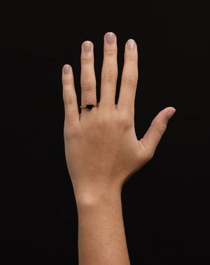 A silver ring with a heart-shaped cut stone set in a simple claw setting on a delicate band. Worn on a hand