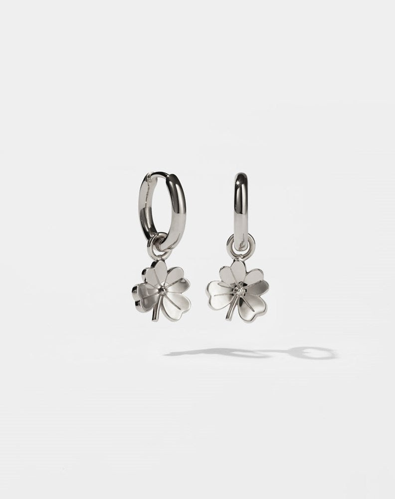 Silver four leaf clover shaped earrings on a white background