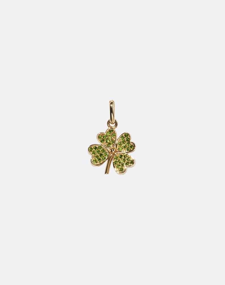 Gold four-leaf clover charm set with green gemstones on a white background