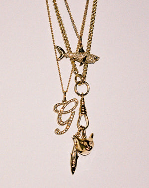 Layered Gold charm necklaces with diamonds. Shark charm,  cat charm,  sardine charm.
