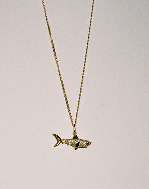 Gold and diamond shark charm pendant necklace.