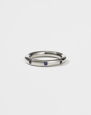 Silver ring with eight blue sapphires set on a white background