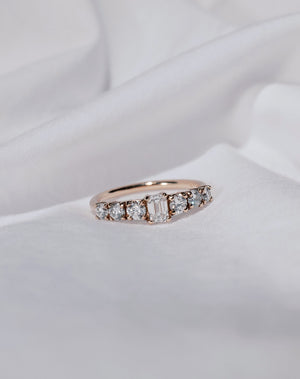 Diamond ring with rose gold band set with seven white diamonds.