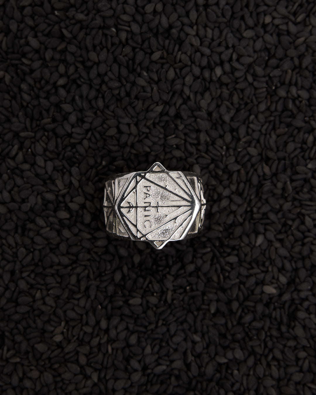 Silver ring with geometric design and the word panic. In collaboration with artist Andrew Mcleod