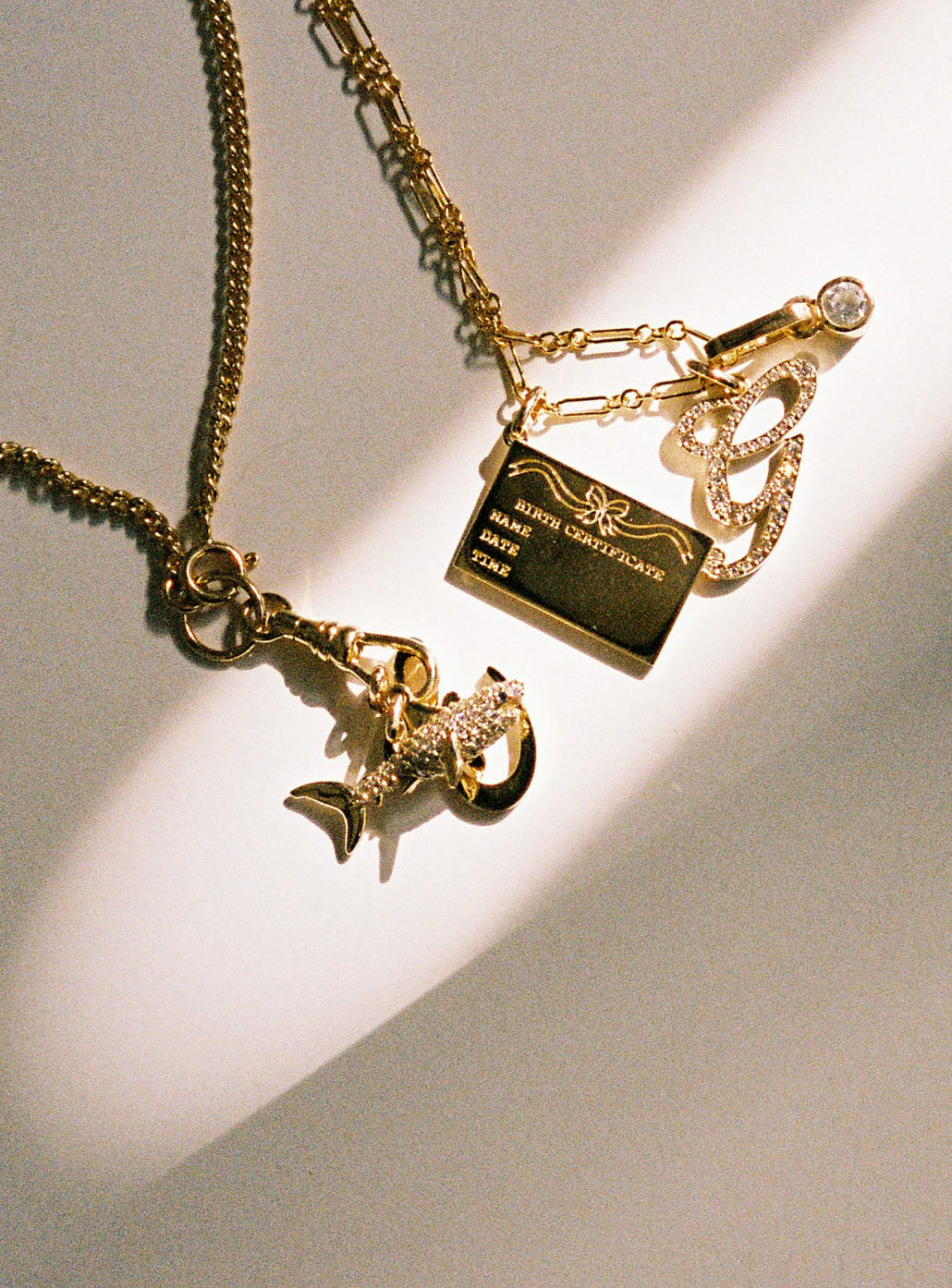 Gold necklace with charms on a light background