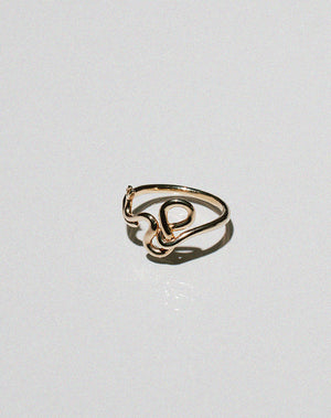 Gold snake ring curving and wrapping into a band.