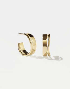 A pair of gold-plated hoop earrings, showcasing a minimalist and organic design.