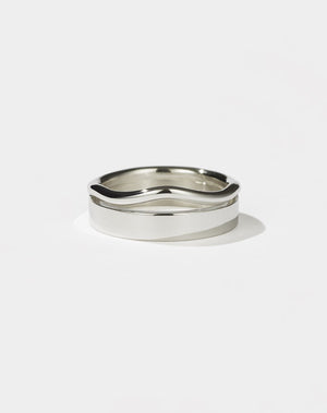 A sterling silver ring with a flat, minimalist band and an organic, curvy rounded band.