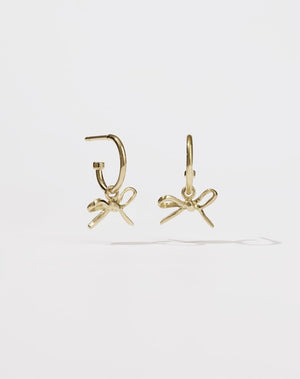 Gold hoop earrings with a small bow charms