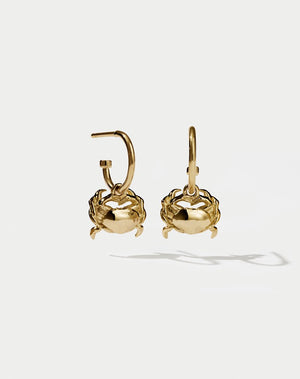 A pair of gold-plated hoop earrings with crab-shaped charms attached to them