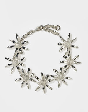 A sterling silver bracelet featuring a chain link design with seven daisy flower motifs