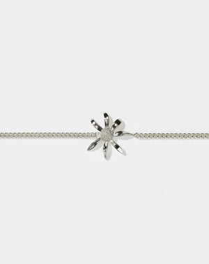 A sterling silver daisy charm bracelet with a classic curb chain design, featuring a single daisy charm centered on the bracelet.