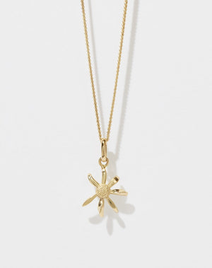 A gold daisy charm necklace on a fine chain