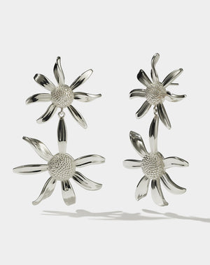 A pair of sterling silver drop earrings, featuring a stud back flower design with a larger flower dangling below.