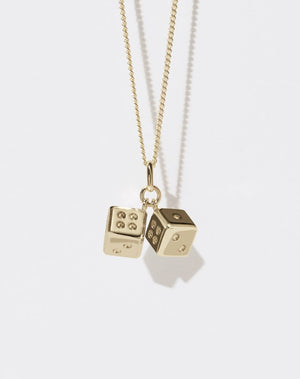 A gold chain necklace featuring a playful pair of dice charms.