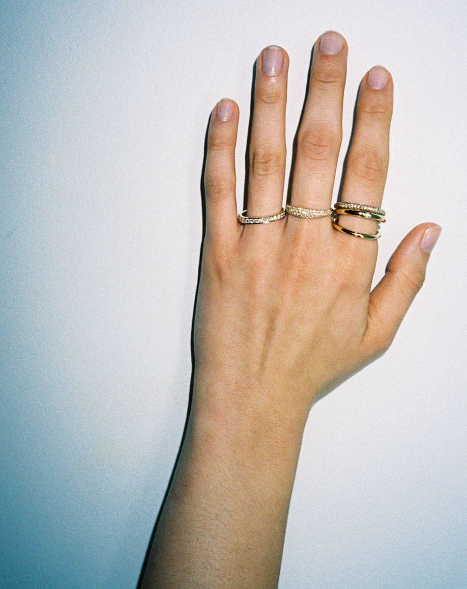 Glowing Eternity Band, Mini Claude Ring Triple Pave, Halo Triple Pave Band and Coco Ring in 9ct Yellow Gold with pave set round brilliant cut white diamonds. Worn on model hand.