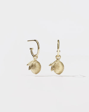 A pair of gold hoop earrings with lemon charm pendants attached