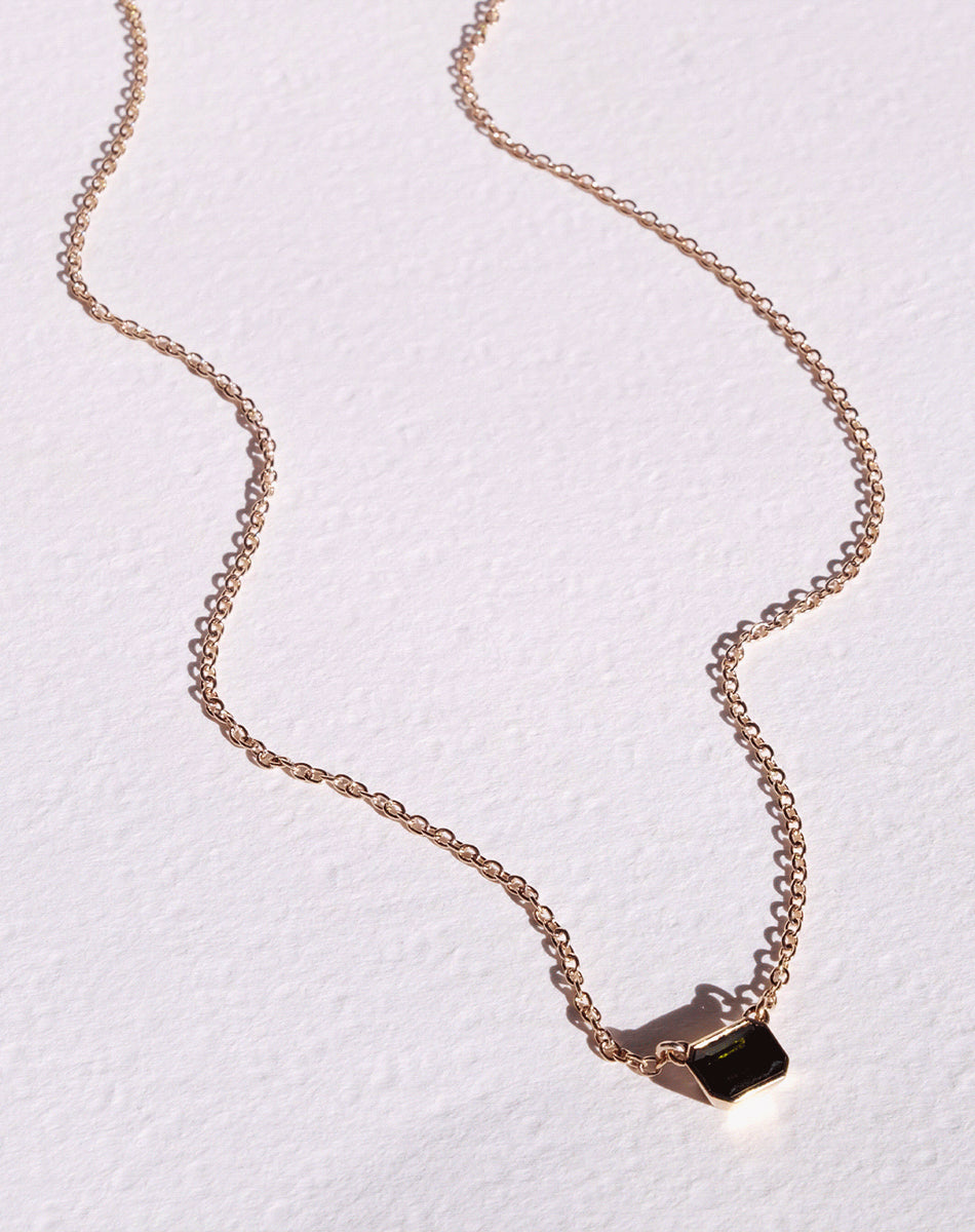 Meadowlark Jewellery's Limited Edition Milan Necklace in 9ct Yellow Gold with an emerald-cut green tourmaline stone held boldly in a distinctive bezel setting. Hung from an adjustable 40cm-45cm fine chain necklace. A classic and timeless design, perfect to stack with your favourite chains or a minimalist piece for everyday. Made to order in New Zealand, at the Meadowlark workshop.