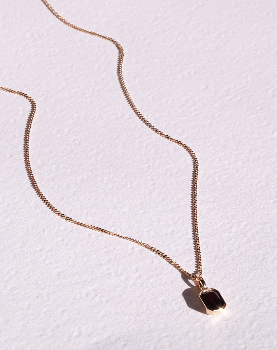 Meadowlark Jewellery's Limited Edition Milan Necklace in 9ct Yellow Gold with an emerald-cut Thai garnet stone held boldly in a distinctive bezel setting. Hung from a 40cm fine chain necklace. A classic and timeless design, perfect to stack with your favourite chains or a minimalist piece for everyday. Made to order in New Zealand, at the Meadowlark workshop.