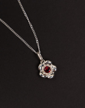 Meadowlark Jewellery’s floral Posie Charm Necklace in Sterling Silver, set with a single round brilliant cut African Garnet stone. Hung from a fine diamond curb chain. Inspired by classic floral motifs and our beloved Alba designs, a timeless symbol of grace, growth and renewal. Celebrating life’s continual renewal. From the Dreams collection.