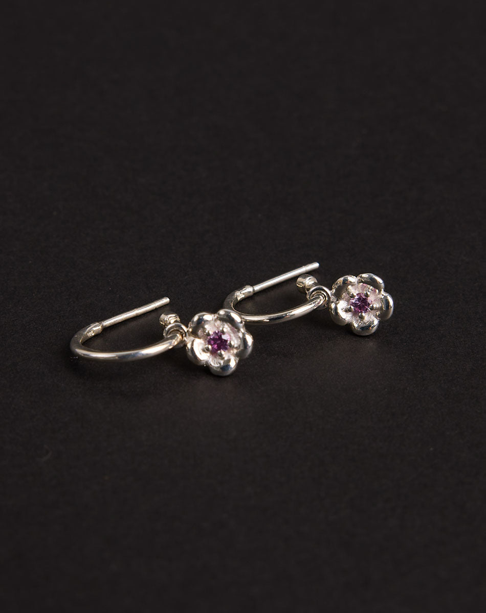 Meadowlark Jewellery’s floral Posie Signature Hoop Earrings in  Sterling Silver, set with a single round brilliant cut Pink Sapphire stone. Hung from classic signature hoop earrings. Inspired by classic floral motifs and our beloved Alba designs, a timeless symbol of grace, growth and renewal. Celebrating life’s continual renewal. From the Dreams collection.