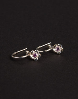 Meadowlark Jewellery’s floral Posie Signature Hoop Earrings in  Sterling Silver, set with a single round brilliant cut Pink Sapphire stone. Hung from classic signature hoop earrings. Inspired by classic floral motifs and our beloved Alba designs, a timeless symbol of grace, growth and renewal. Celebrating life’s continual renewal. From the Dreams collection.