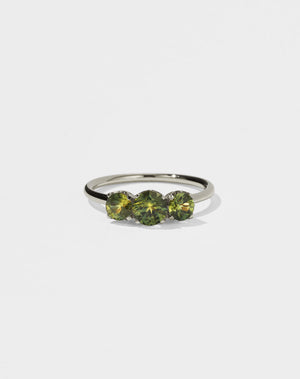 A classic three stone engagement ring in white gold with green sapphire.