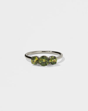 A classic three stone engagement ring in white gold with green sapphire.