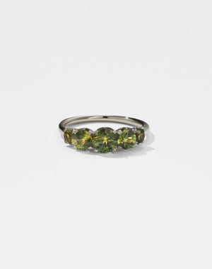 A classic white gold, five stone diamond engagement ring. Set with green sapphires.