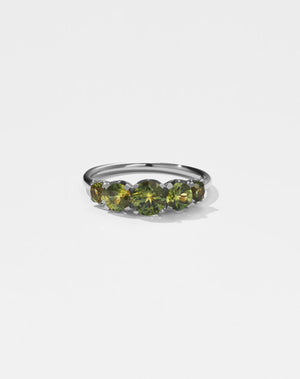 A classic white gold, five stone diamond engagement ring. Set with green sapphires.