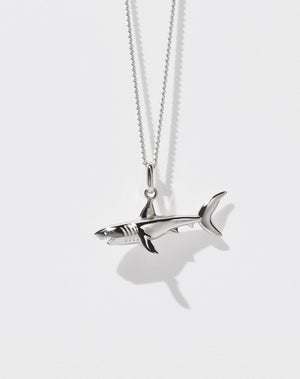 A sterling silver shark charm necklace with a fine chain.