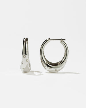 A pair of sterling silver hoop earrings designed to resemble strawberries, with abstract circles representing seeds.