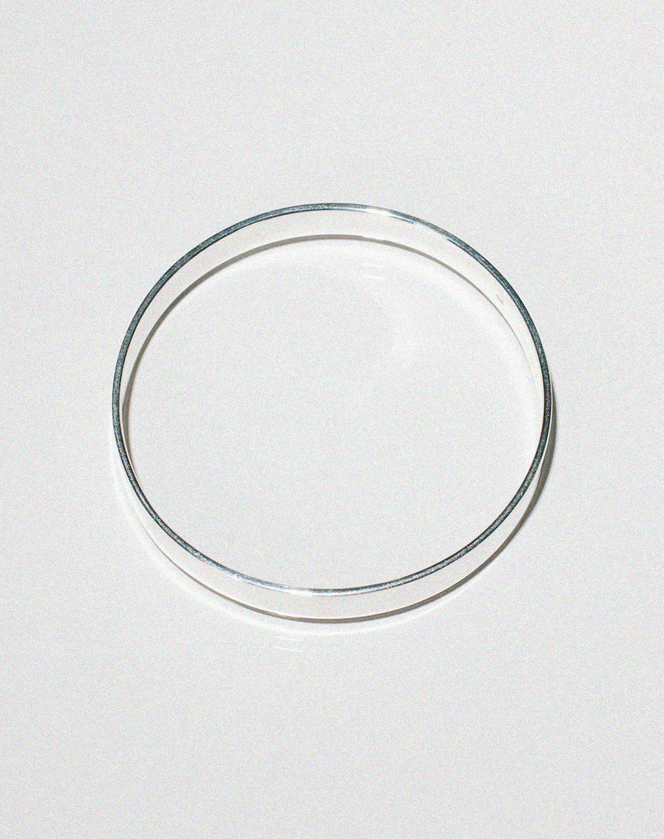 Flat silver bangle, shown from the side.