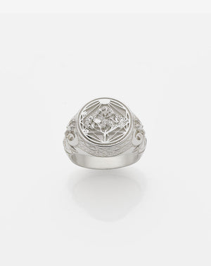 A sterling silver ring featuring a heavy weighted design with a central artwork, collaged together, with intricate detailing.