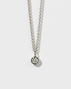 A sterling silver necklace with a round brilliant stone in a bezel setting on a fine chain.