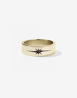 A 9ct yellow gold flat band with a central ruby set in an elongated star setting, creating a dramatic effect.